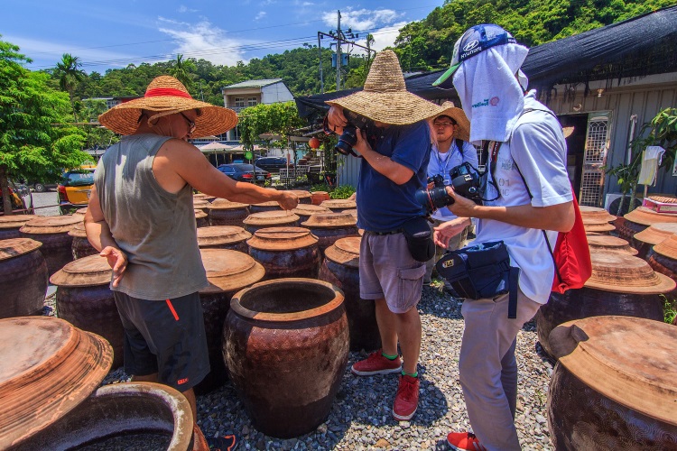 台湾休閒农场 感受悠游时光 参赛着头戴草帽,顶着烈阳高温下,在老妈妈手工酱油赛场拍摄。