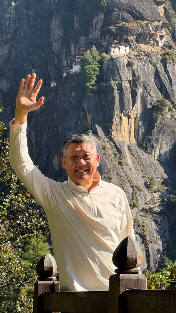 Man waving with monastery cliffside