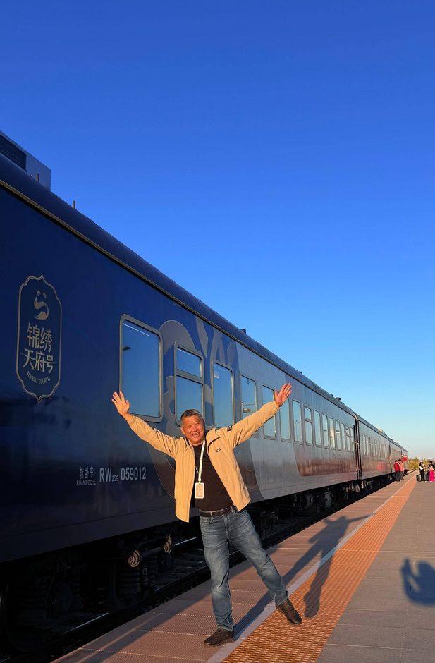 李桑 ‧ 乘坐“锦绣天府号”列车 ‧ 悠游南北疆10488公里文 Man waving by train.